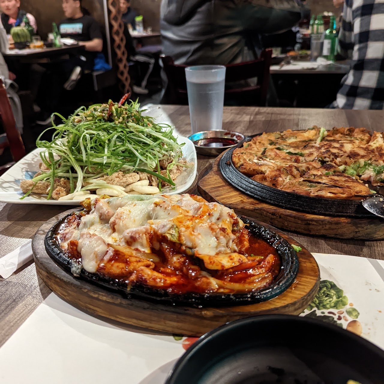 A spread of Korean fusion dishes and soju on a table at Dae Bak